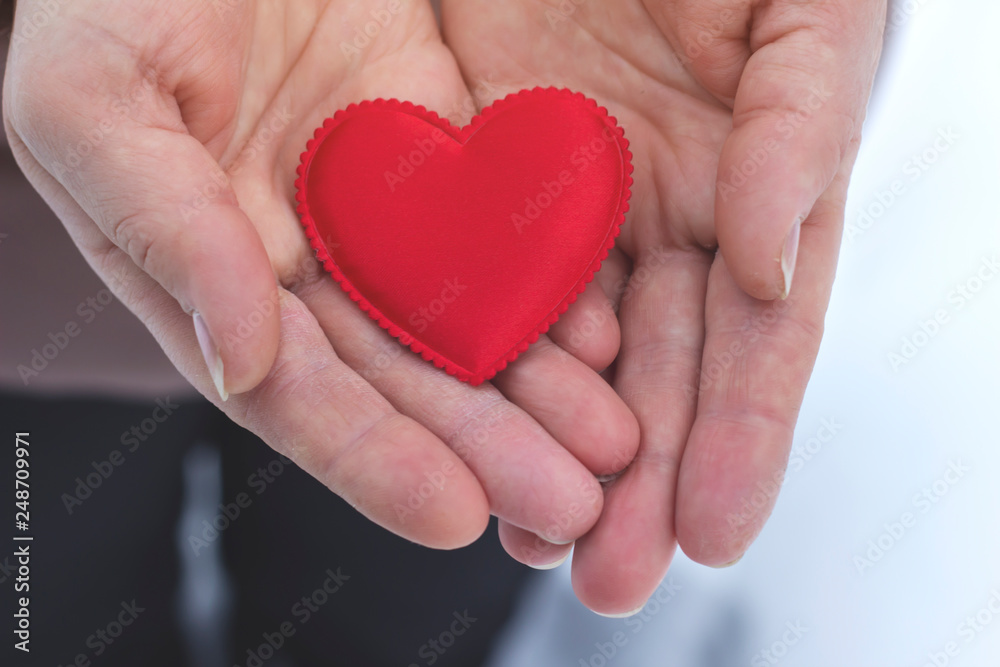 Woman holding a red heart in winter weather Woman holding a red heart in winter weather