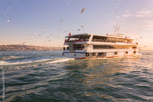 A tourist ship sails through the Bosphorus. Istanbul, Turkey. View of the city. Tourism and travel.