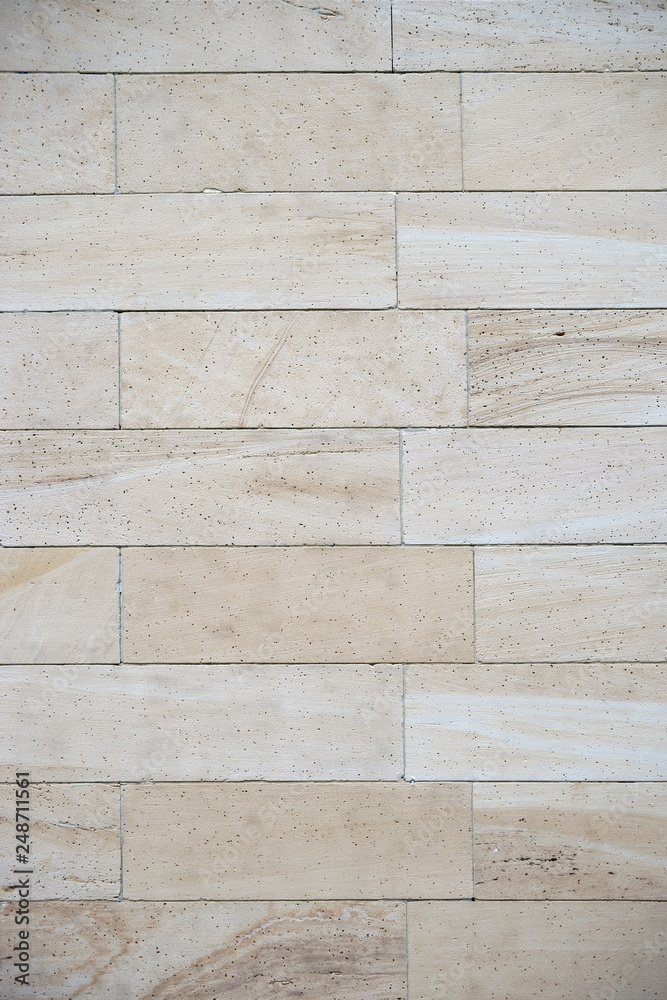 Fototapeta premium Eine hellbeige Fassadenverkleidung aus marmoriertem Sandstein mit Poren. .