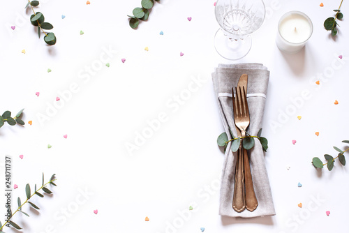 Fototapeta Naklejka Na Ścianę i Meble -  Concept flat lay with floral decorations and cutlery on the white backdround. Top view Valentines day, Mothers day or Easter card