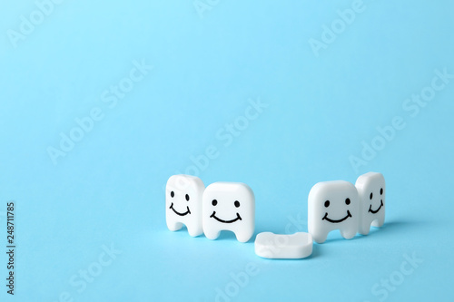 Composition with small plastic teeth on color background. Space for text