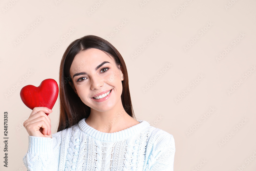 Portrait of young woman with decorative red heart on color background, space for text Portrait of young woman with decorative red heart on color background, space for text