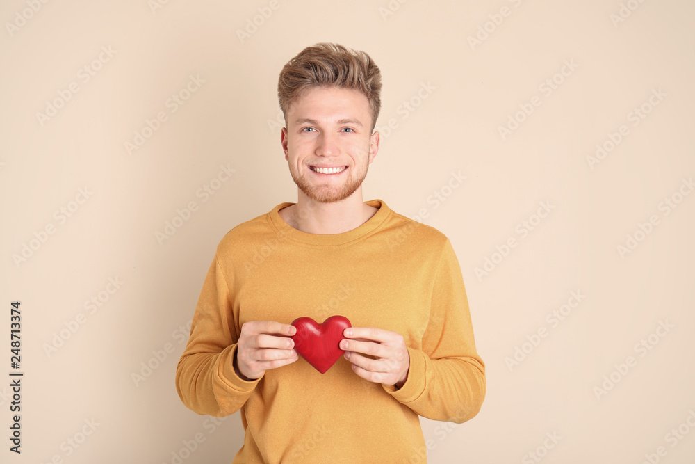 Portrait of young man with decorative heart on color background Portrait of young man with decorative heart on color background