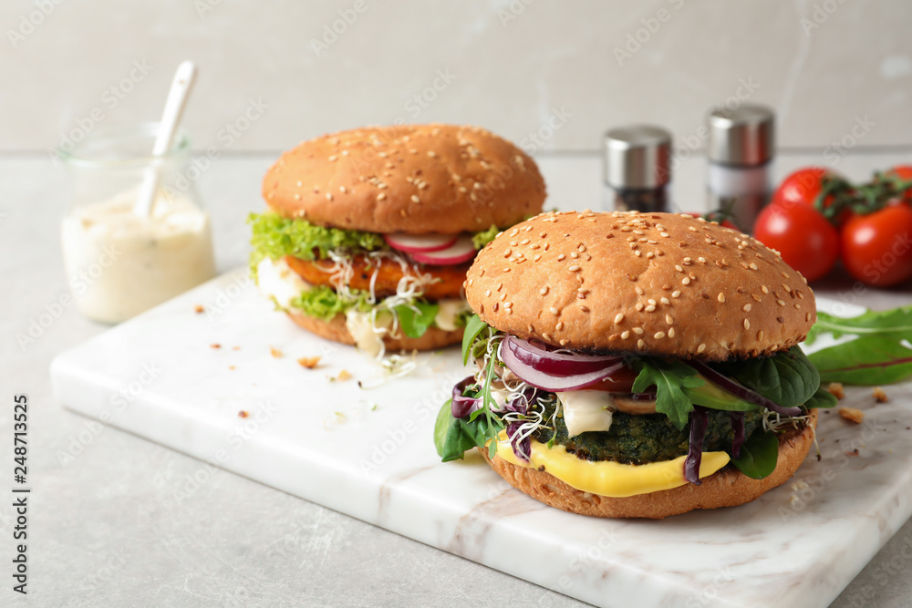 Board with tasty vegetarian burgers on table Board with tasty vegetarian burgers on table