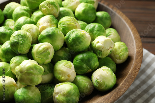 Fresh Brussels sprouts in bowl on table, closeup
