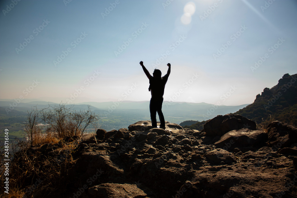 Happy man who celebrates reaching the chasm and observing the horizon in the chasm of a viewpoint that is located in a state of Mexico on the great hill of the speaker