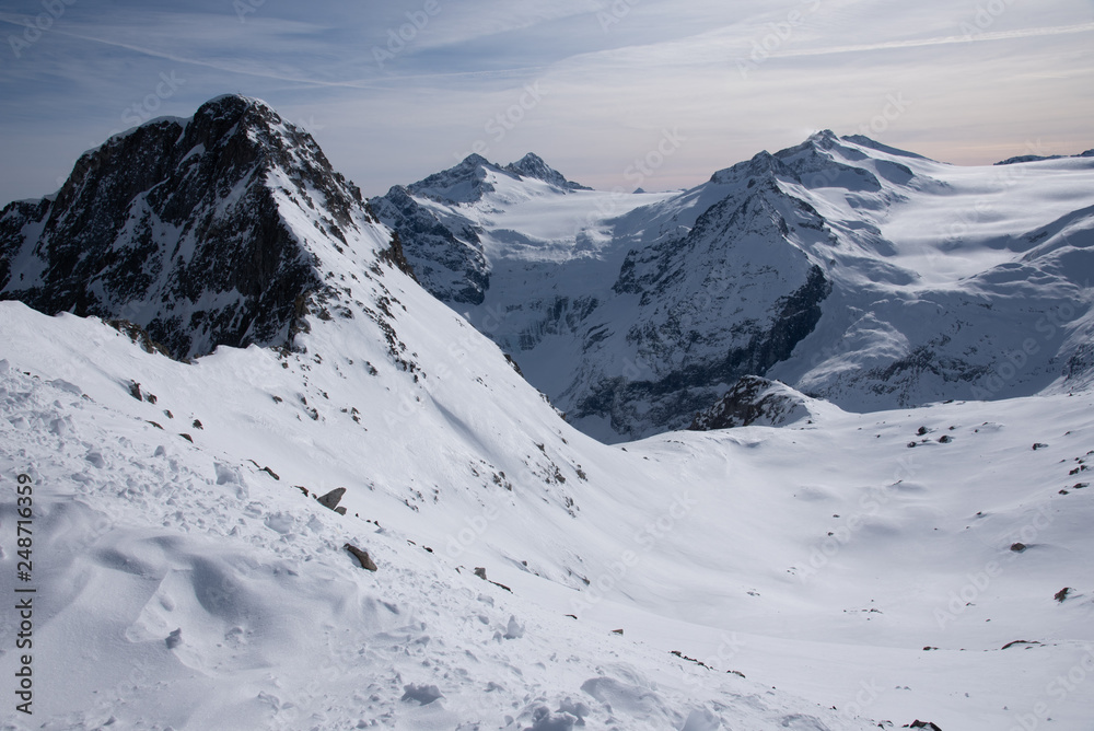 Obraz premium View of the Presena glacier at 3100 meters of altitude and the mountains around the Tonale Pass, during a winter sunny day. Tonale is a mountain pass between Lombardy and Trentino