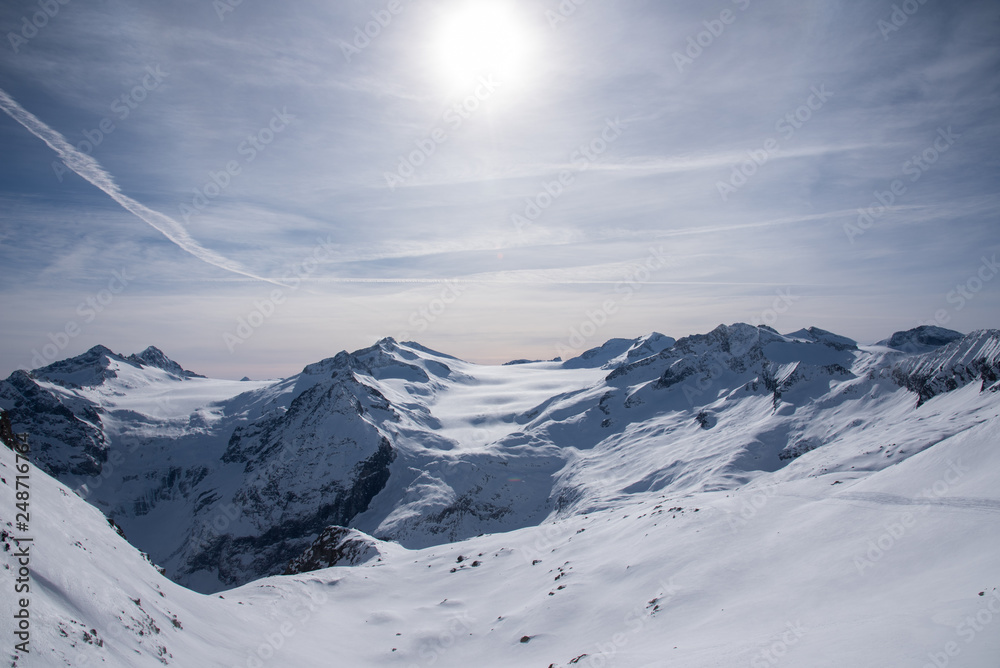Obraz premium View of the Presena glacier at 3100 meters of altitude and the mountains around the Tonale Pass, during a winter sunny day. Tonale is a mountain pass between Lombardy and Trentino