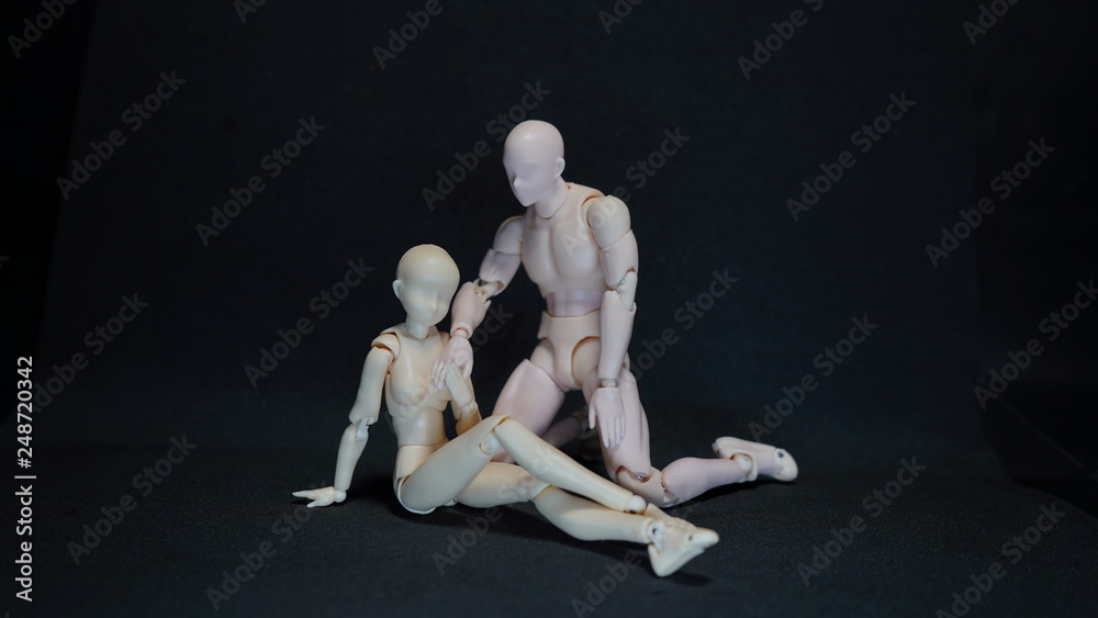 Two mannequin art models representing a romantic embrace on black background. concept of feelings Two mannequin art models representing a romantic embrace on black background. concept of feelings
