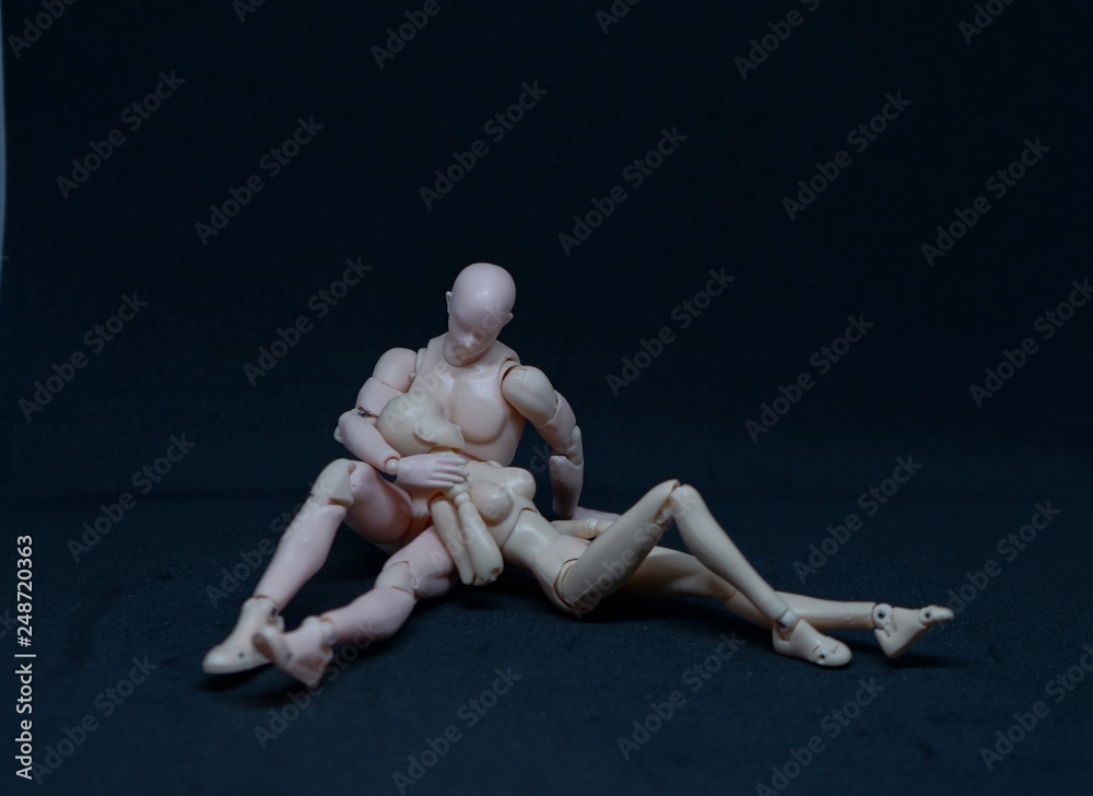 Two mannequin art models representing a romantic embrace on black background. concept of feelings Two mannequin art models representing a romantic embrace on black background. concept of feelings