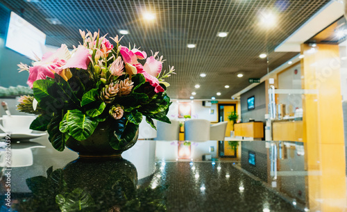 Flowers vase on table in lobby area with copy space