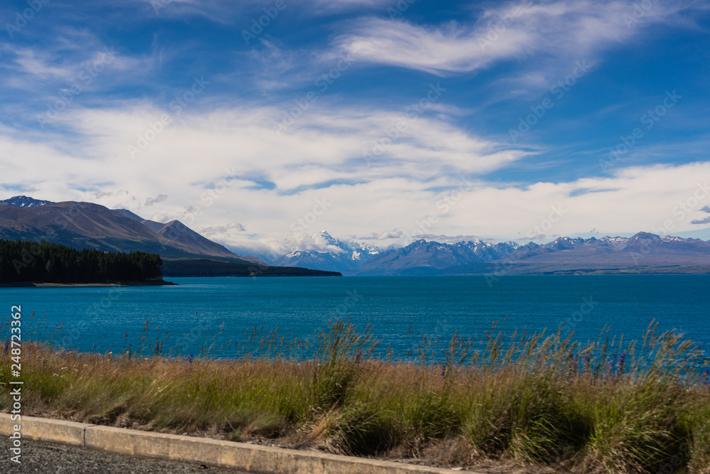 Lake Pukaki view from Glentanner Park Centre near Mount Cook, on a background of blue sky with clouds, snowy Southern Alps