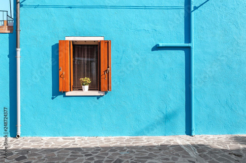 Picturesque window in blue colorful house as design concept