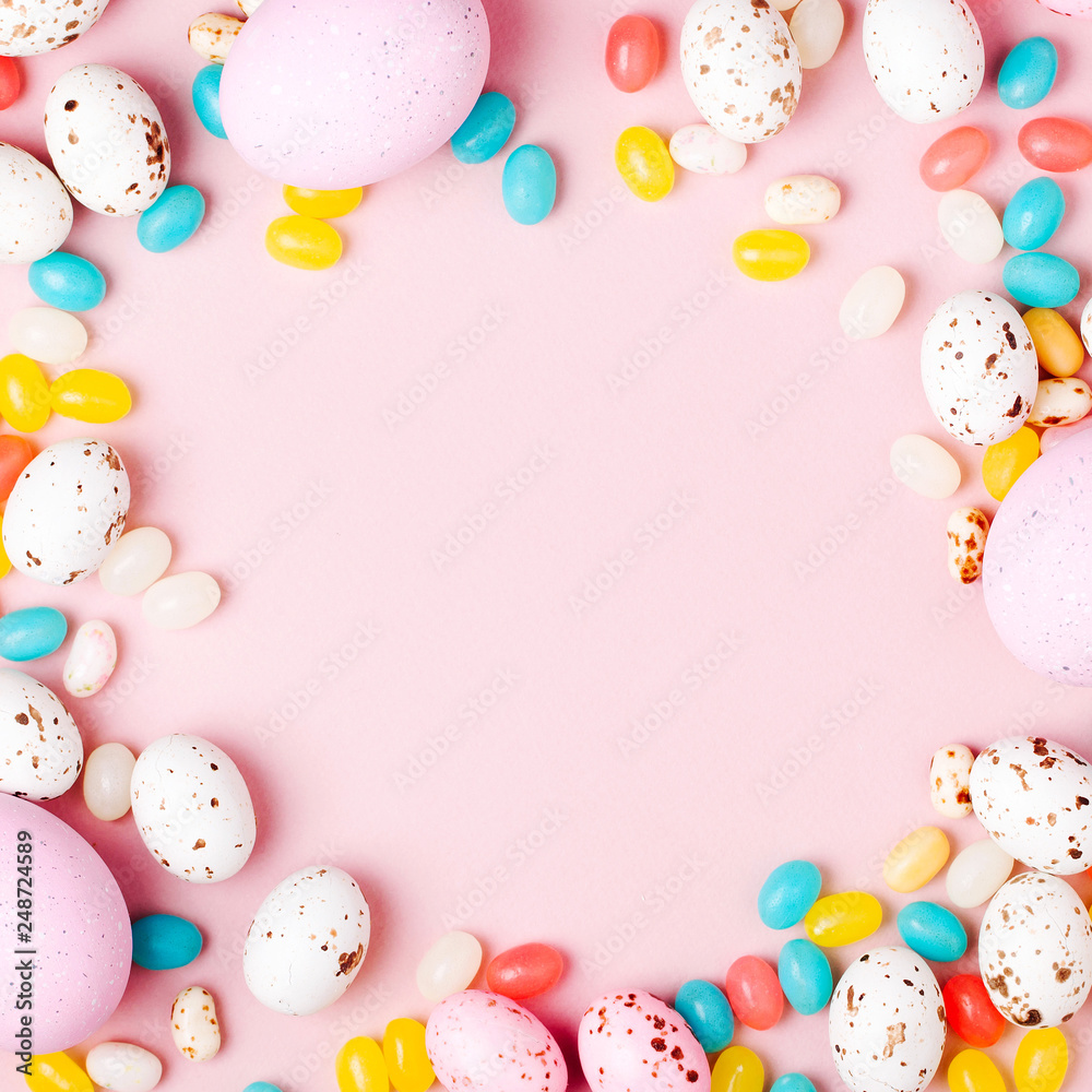 Stylish frame made of Easter candy chocolate eggs and Jellybean on pink background Stylish frame made of Easter candy chocolate eggs and Jellybean on pink background