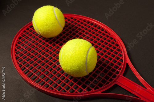 two tennis ball and red racket © Aleksandr Ugorenkov