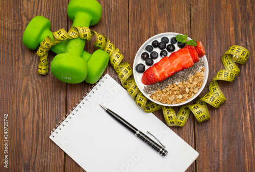 Dumbells, tape measure and healthy food. Fitness