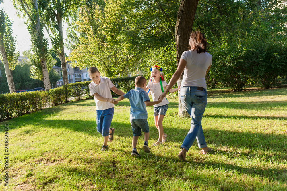 Mother and children dance on the lawn in the park Mother and children dance on the lawn in the park