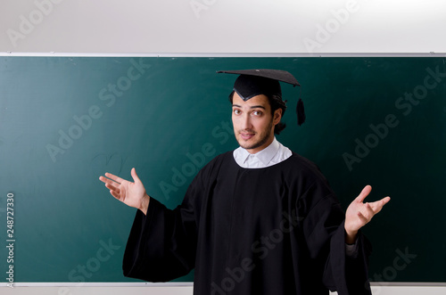 Graduate student in front of green board