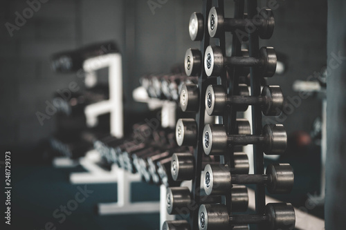 Stand with dumbbells in the gym, dumbbell set. Many dumbbells in the fitness club