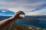 holding a lens ball at the top of Roys peak in New Zealand, crystal ball on the top of a mountain in New Zealand, Roys peak image, lens ball photography