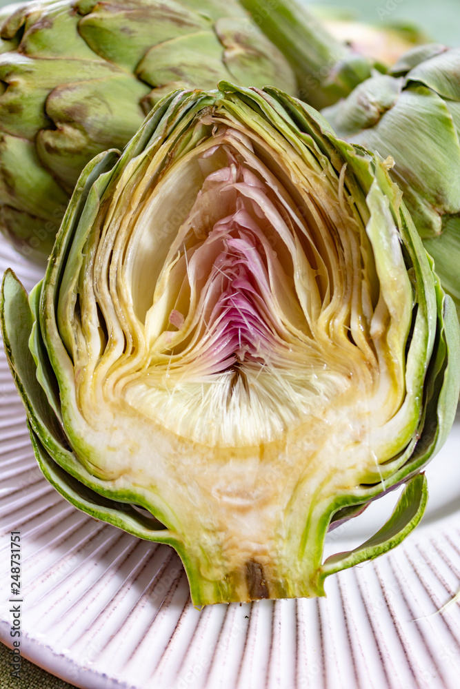 Obraz premium Heads of fresh uncooked artichoke flowers close up