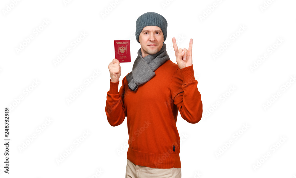 The Caucasian man with the international passport of the Russian Federation in warm clothes. Shows two fingers, gesture - a goat