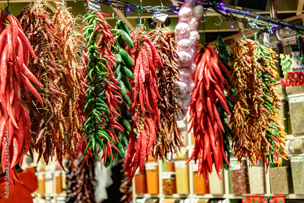 The pods of various peppers hanging in the market.
