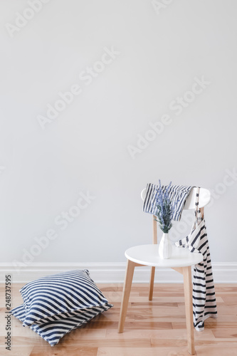 Interior with chair, striped cushions and clothes
