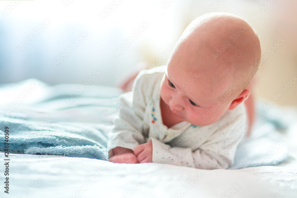 A small child confidently holds his head. The first skills of the child. Child development by months. The first month of life a healthy baby. A small child confidently holds his head. The first skills of the child. Child development by months. The first month of life a healthy baby.