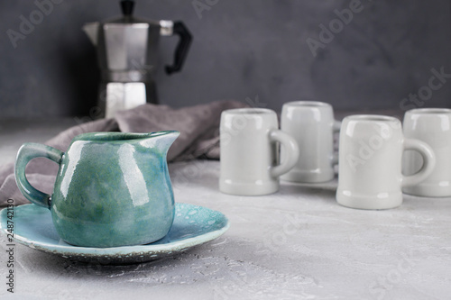 Set of grey rustic coffee cup handcraft and geyser coffee maker against shabby grey wall. Natural handmade crockery tableware