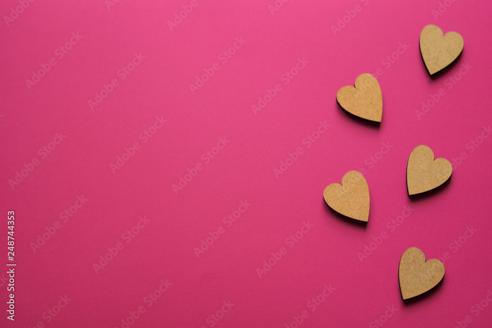 Little wooden hearts on pink background. Romantic composition with copy space for greeting. Little wooden hearts on pink background. Romantic composition with copy space for greeting.