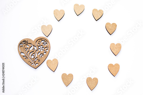 Happy Valentine's day! Round frame of wooden hearts on white background with copy space. Concept of spring, love, feelings, lightness, tenderness.