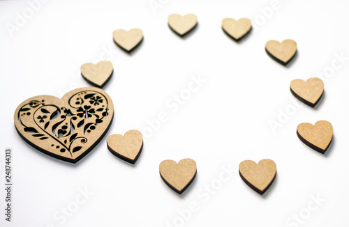 Concept of spring, love, feelings, lightness, tenderness. Happy Valentine's day! Round frame of wooden hearts on white background with copy space.