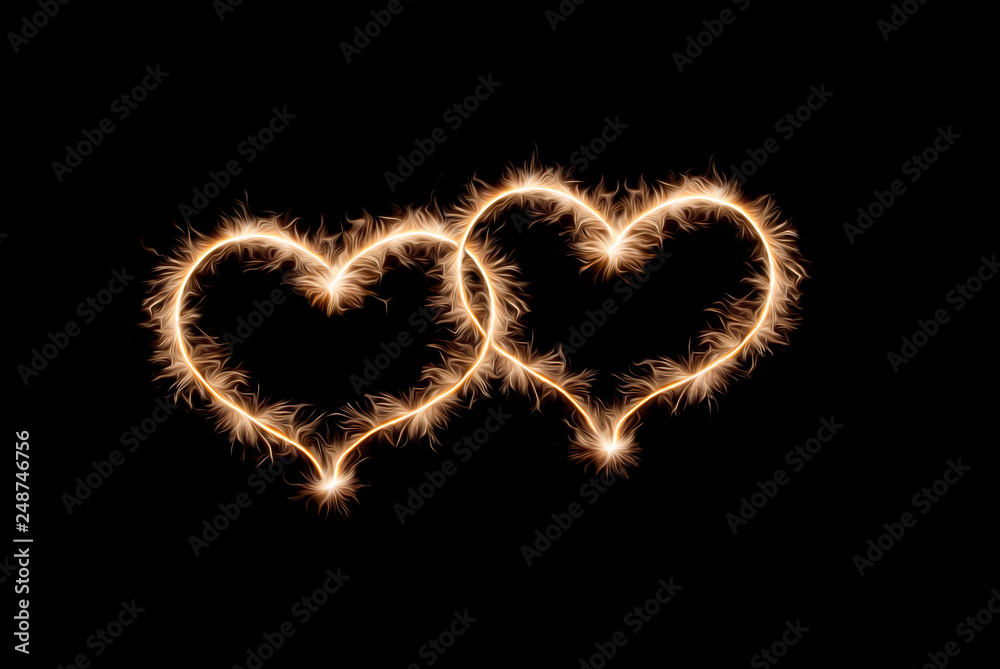 Two hearts drawn by sparklers on a black background. Two hearts drawn by sparklers on a black background.