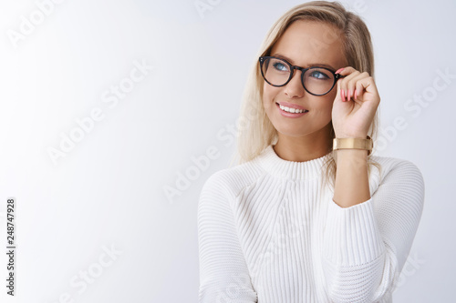 Foto Successful stylish and elegant young lady in glasses and sweater looking delight