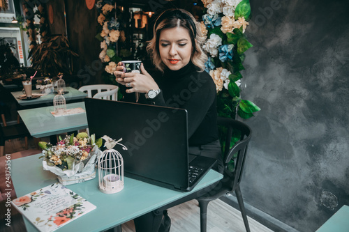 Girl typing on laptop and drinking coffee