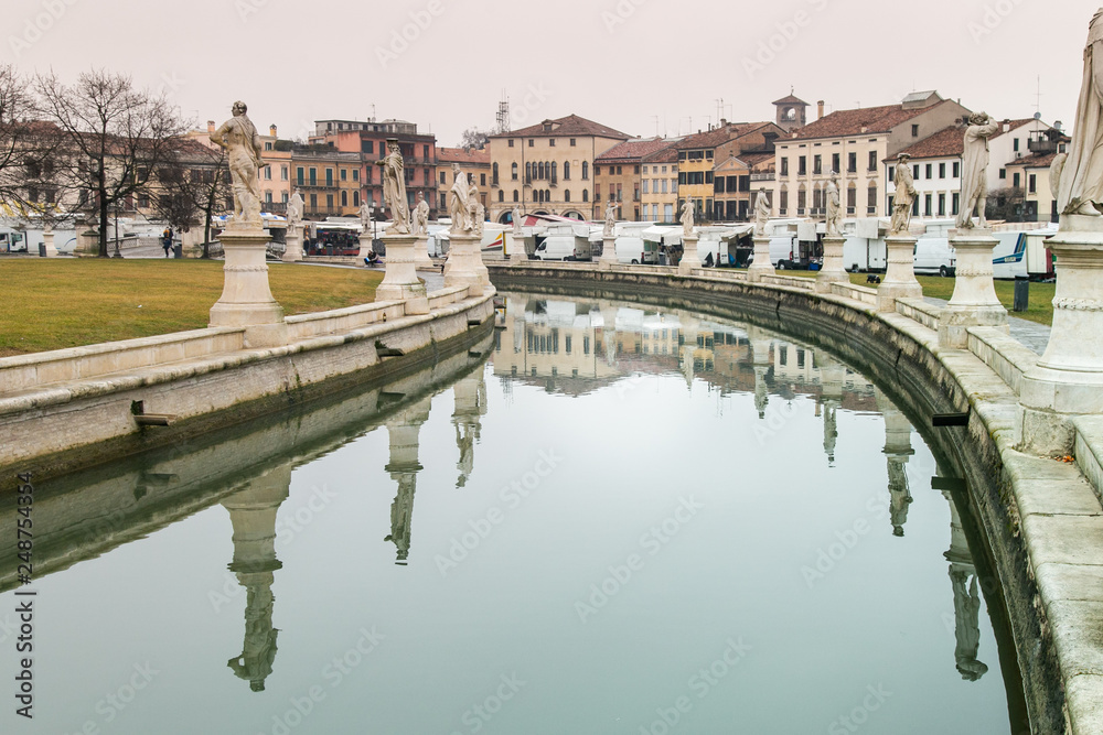 Statues reflect on canal water in Prato della Valle Square in Padua, Italy