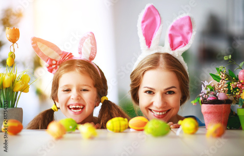 Happy easter! family mother and child daughter with ears hare getting ready for holiday