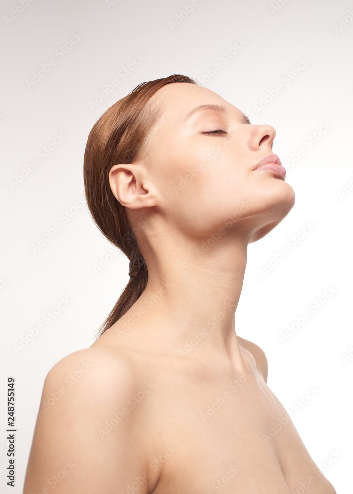 Beauty portrait of young girl with brown hair and big lips on white background with clean face skin and arm near head. Good for cosmetic, medicine and spa . European type