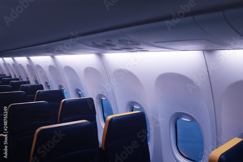 Interior of the passenger aircraft with a seat and portholes.