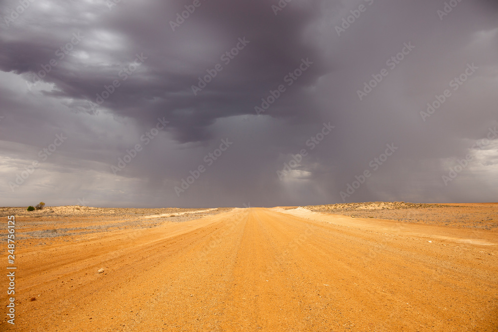 Oodnadatta Track, South Australia; yellow dirt road with storm clouds and horizon