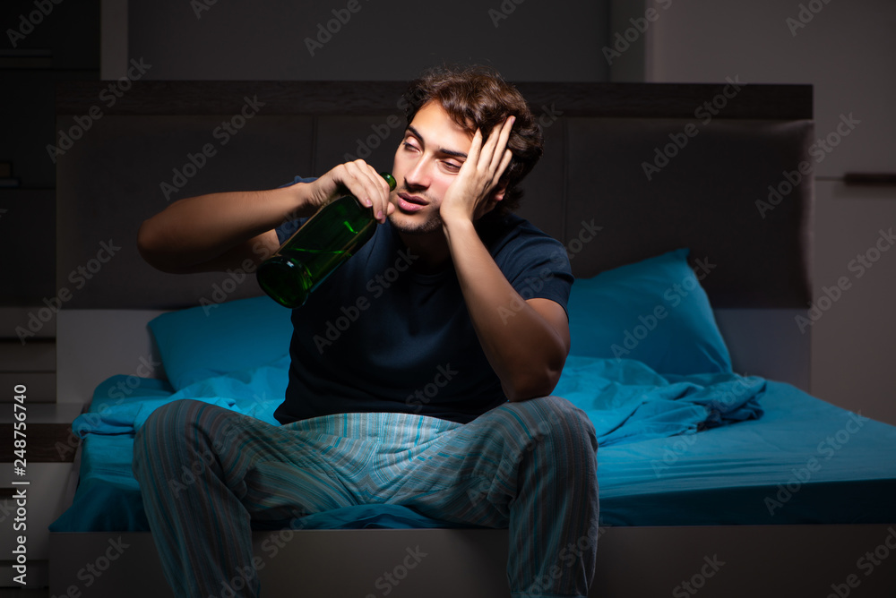 Man drinking in the bed under stress Man drinking in the bed under stress