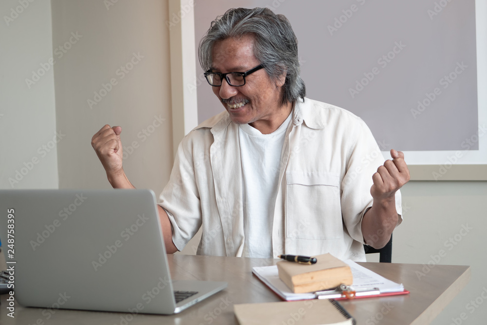 Happy Senior Asian man connected on laptop computer. Success business online at home. startup small business owner, for online after retirement Happy Senior Asian man connected on laptop computer. Success business online at home. startup small business owner, for online after retirement