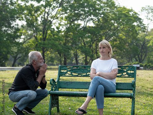 Senior couple having problem, conflict, sadness, do not understand in a park.