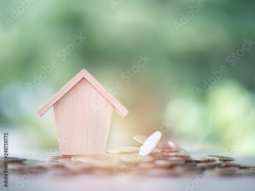 Money coin with wooden house on nature background. Property investment and house mortgage financial, Credit home concept with copy space