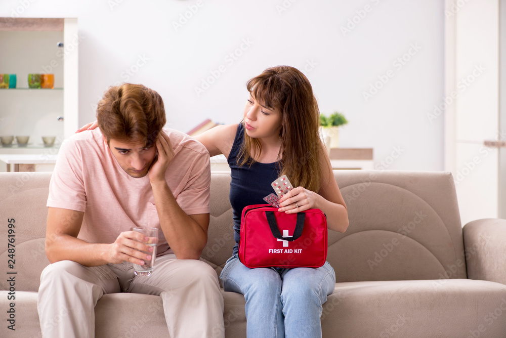 Young family getting treatment with first aid kit Young family getting treatment with first aid kit