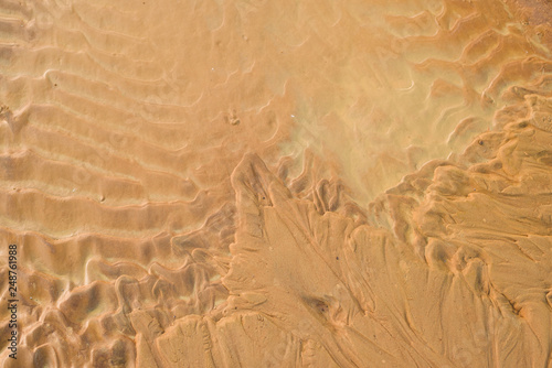 Close-up Fine beach sand dunes in the summer sun smooth texture as background. Aerial top drone view