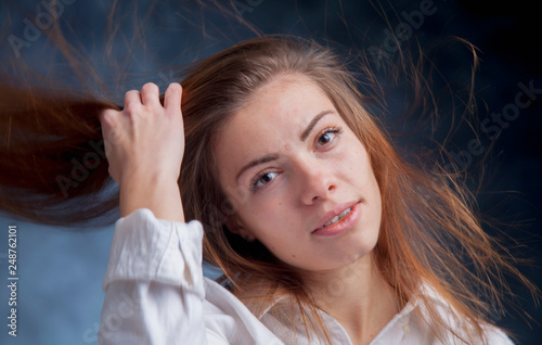 Portrait of happy beautiful young woman with hair developing on a wind. Happiness and freedom concept.