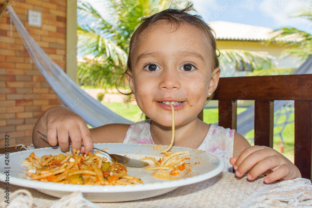 Criança comendo macarrão ao ar livre Criança comendo macarrão ao ar livre
