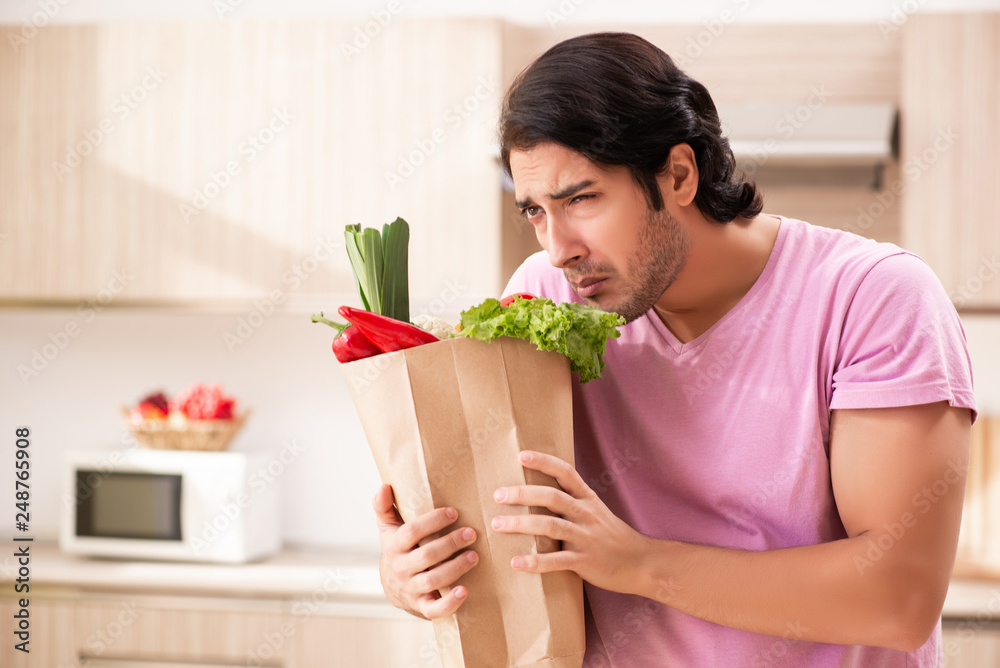 Young handsome man with vegetables in the kitchen Young handsome man with vegetables in the kitchen
